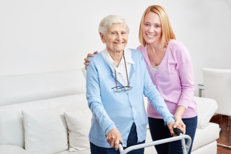 Woman with caregiver at home, representing in-home compression therapy for leg ulcers.
