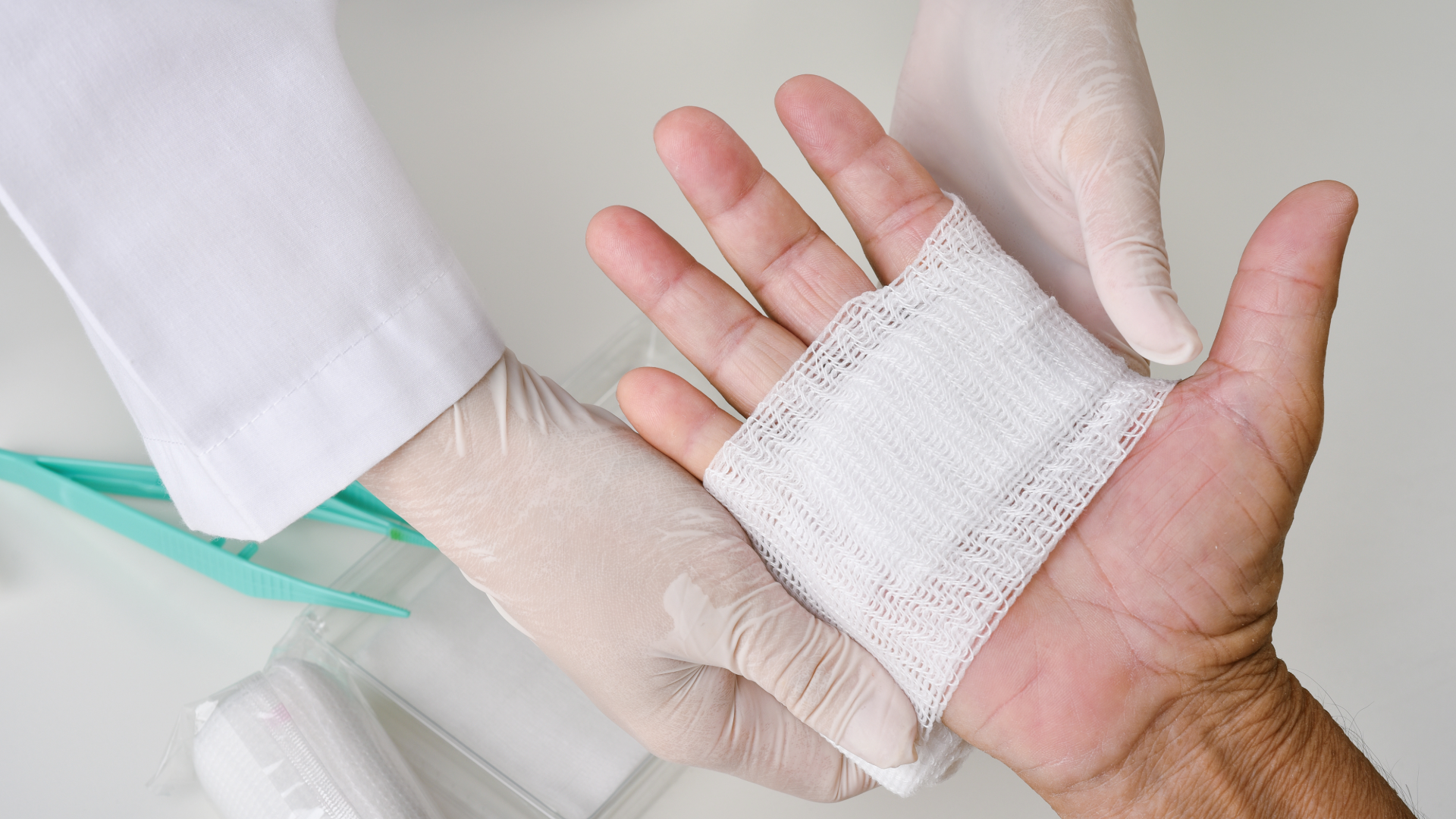 Healthcare professional performing wound debridement and dressing on a patient’s hand