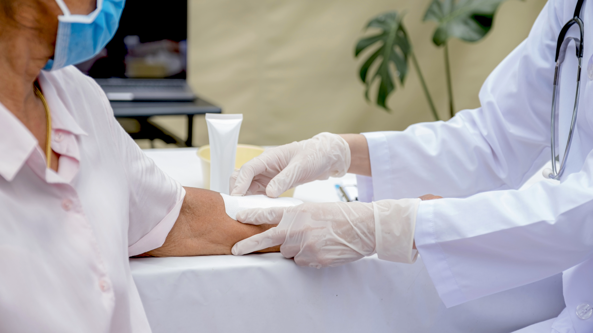 Doctor applying a skin substitute treatment on a patient’s arm during a wound care procedure